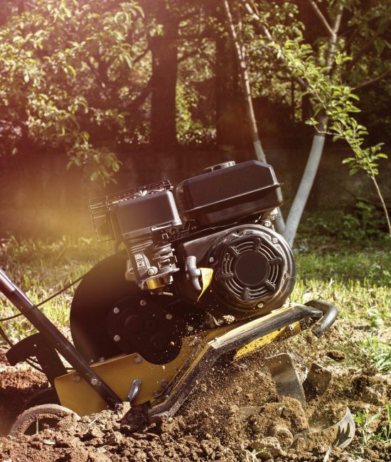 A close up view on motor cultivator during plow process spring season garden works concept.